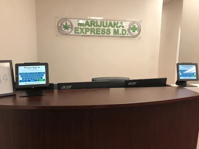 Marijuana Express M.D. reception desk with check-in kiosks and signage for medical cannabis card evaluations.
